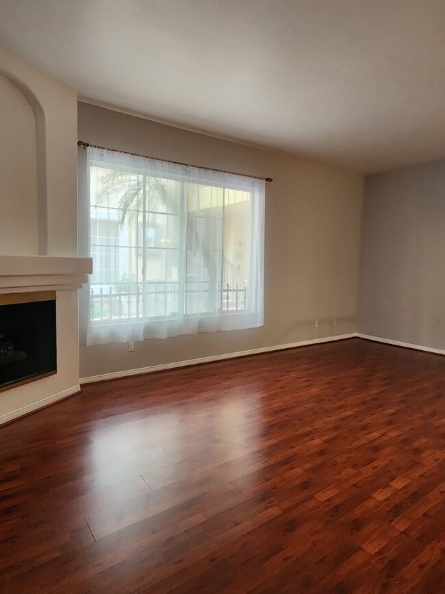 Living room with fireplace and large window - 7037 La Tijera Blvd Condo Unit A101