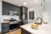 Modern cabinetry with stainless-steel appliances & quiartz countertops - Kanvas Apartments
