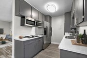 Spacious kitchen with stainless steel fridge, oven, and microwave. - Woodbridge Park Apartments