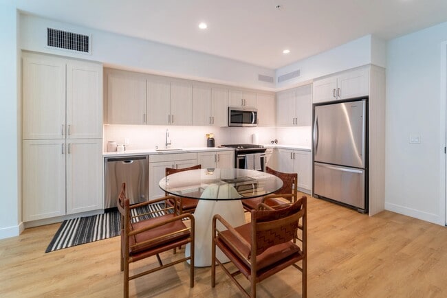 Kitchen with bright cabinetry, stainless steel appliances, and generous storage, paired with a dedicated dining area for everyday meals and gathering. - Upper Ivy