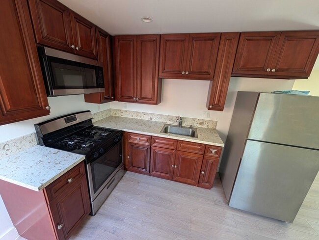 Kitchen with gas range, microwave, and ample cabinet storage - 6534 Peterson Ave