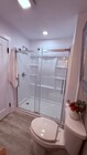 New oversized shower with glass sliders and built-in shelving. - 24606 University Ave
