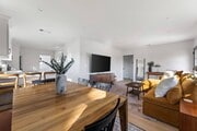 Living room with West Elm furniture, natural sunlight, and large TV flatscreen. - 1823 N Ditman Ave House
