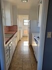 kitchen w/ range/oven, refrigerator, washer & dryer leading to backyard - 900 Patterson Ave Condo Unit 900 Patterson Avenue