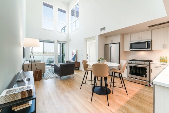 Loft-style home with soaring ceilings, oversized windows, and an open kitchen that fills the space with natural light and expansive views. - Upper Ivy