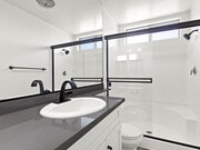 Modern styled bathroom with shower and tub. - Cedar Glen Apartments