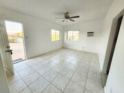 Living room with ceiling fan and natural light - 5527 Baileya Ave Unit A