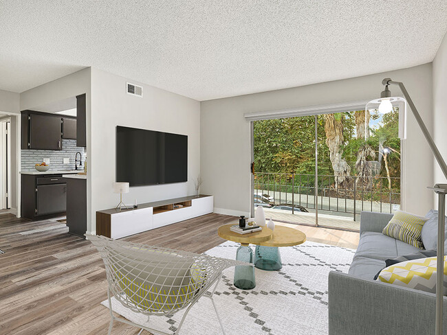 Hardwood floored living room with view of balcony and kitchen. - Sherman Oaks Gardens