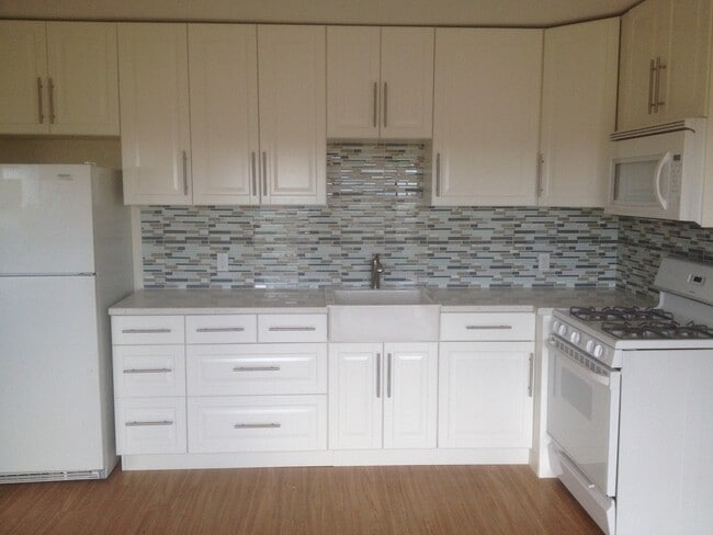 Galley kitchen with quartz countertops, apron sink - 5937 Mildred St House Unit 1