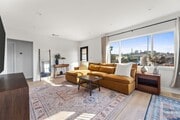 Living room with West Elm furniture, natural sunlight, and large TV flatscreen. - 1823 N Ditman Ave House