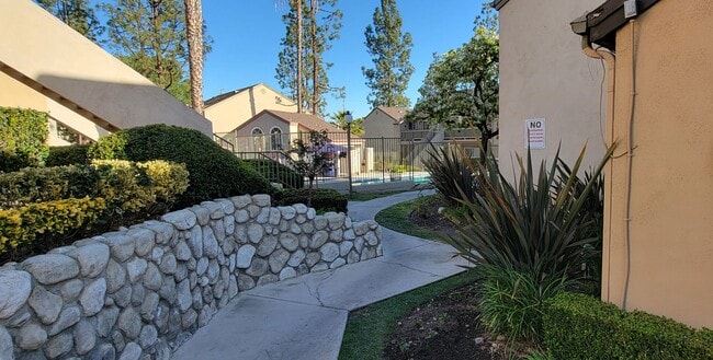 Beautifully landscaped walkway to one of the pools at Northwood Apartments in Upland, California. - Northwood Apartments