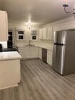 Wide view of kitchen with quartz countertops, and stainless steel appliances. - 24606 University Ave Townhome