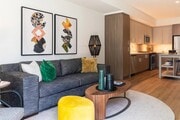 Open-concept home with warm wood-tone cabinetry, stainless steel appliances, and a connected living area designed for comfort and everyday ease. - Upper Ivy