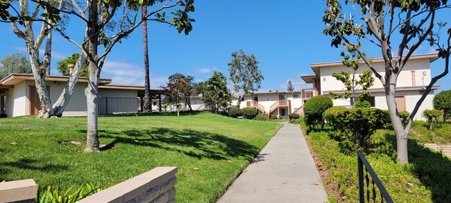 Walkway between apartment buildings at Plaza Verde Apartments in Escondido, California. - Plaza Verde