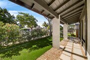 The exposed beam overhang and stucco columns frame a manicured private front lawn - 5214 Dawes Ave