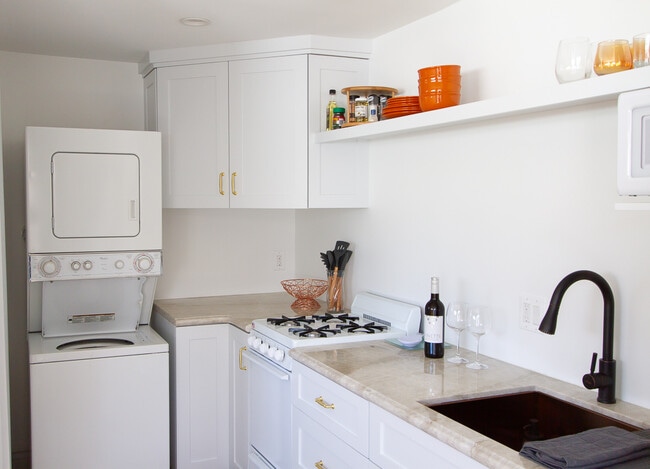 A full kitchen with: French brass sink, ample storage, washer/dryer, gas stove/oven, fridge/freezer. - 2150 Euclid Ave Unit A