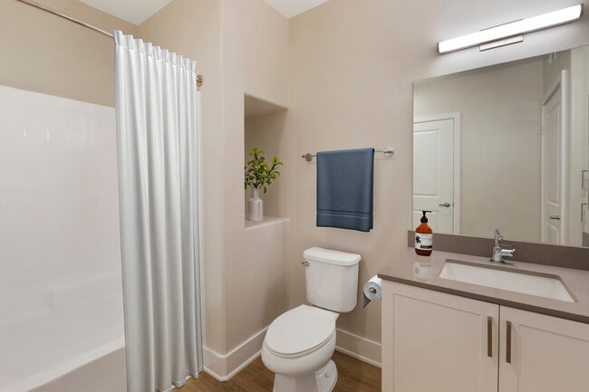 Renovated Package I bath with grey quartz countertops, white cabinetry, and hard surface flooring - Avalon Encino