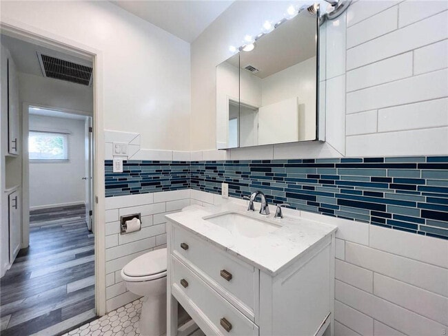 Updated bathroom with white shaker cabinetry, subway tile, glass inlay and more - 1500 Voorhees Ave