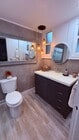 Fully renovated bathroom with modern vanity + designer lighting. - 24606 University Ave