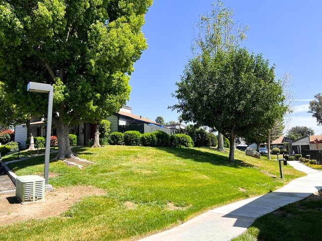 Grassy treed walkway at Dove Ridge Apartments. - Dove Ridge Apartments