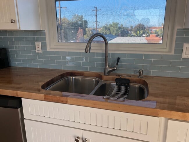 Beautifully sealed butcher block counter tops and 2-tub kitchen sink with disposal. North facing window. - 4470 Swift Ave Unit 4470 Swift