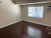 Living room with a wall ac unit - 11280 Morrison St Apartments