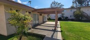 Patio with pergola and mailboxes in grassy courtyard at Plaza Verde Apartments in Escondido, California. - Plaza Verde Apartments