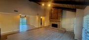 Living room with brick fireplace and dining room - 16139 Ladera Piedra Way