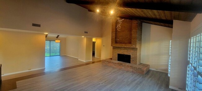 Living room with brick fireplace and dining room - 16139 Ladera Piedra Way