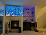 Living room TV, fireplace, bar, mini-fridge, and hidden entertainment center. - 3542 Shoreline Bluff Lane