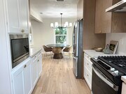 Kitchen with brand new stainless steel appliances to the left and living room to the right - 5950 Simpson Ave