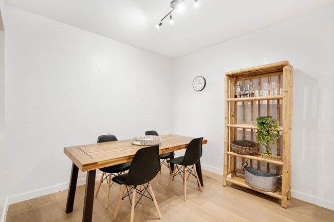 Modern dining room with wood table, open shelving, and seating for six. - 1013 S Sunshine Ave Unit K