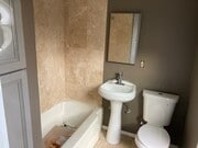 Full tub shower, travertine walls and re-glazed tub. - 1526 E Wilson Ave Unit Studio Apartment