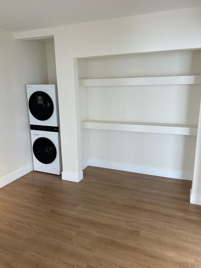 Den showing washer-dryer standing in living room looking toward kitchen. - 1137 12th St Unit #9. 2 bedroom plus den
