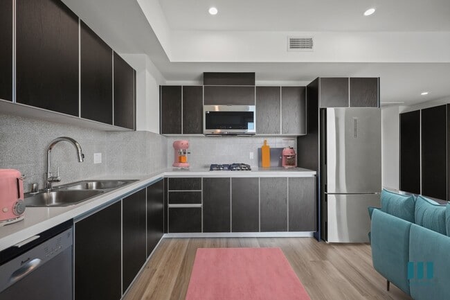 Kitchen with Refrigerator, Range Stovetop, Microwave Oven, Dishwasher, and Ample Cabinet Storage - Sherman Floor Plan - Ogden Garden by Wiseman