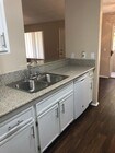 Open kitchen view into living room and dining room, poarch areas at Grande Vista Apartments. - Grande Vista Apartments