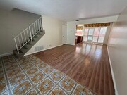 Bright, open living and dining space with large windows and plantation shutters. - 1134 W Huntington Dr Townhome