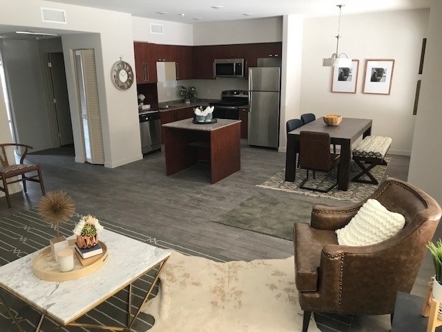 Living room view of dining area and kitchen at City Plaza Apartments in Escondido, California. - City Plaza Apartments