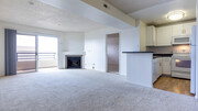 Carpeted Living Room with Fireplace and Balcony - Park West Apartments